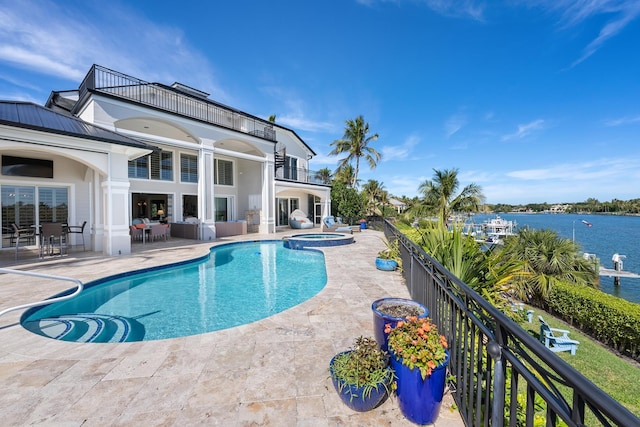 view of swimming pool with a water view, an in ground hot tub, and a patio