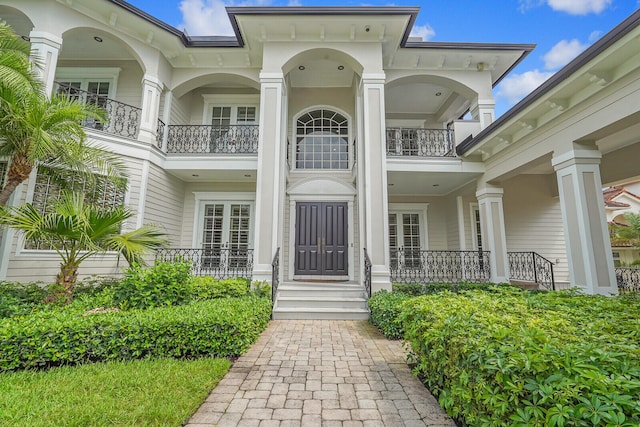 property entrance featuring a porch and a balcony