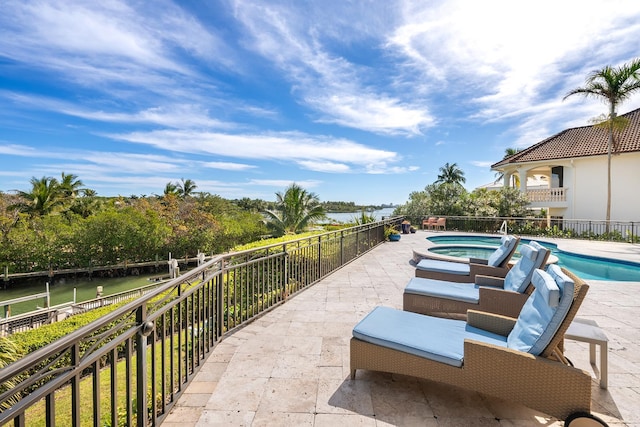 view of patio / terrace featuring a water view and a pool with hot tub