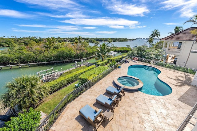 view of swimming pool featuring an in ground hot tub, a water view, and a patio