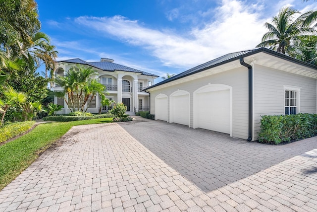 view of front of property featuring a balcony and a garage