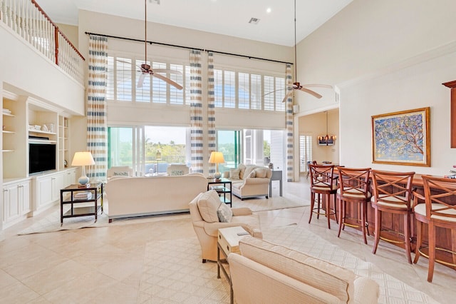 living room with ceiling fan, a towering ceiling, and light tile flooring