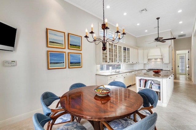 tiled dining room with crown molding, ceiling fan with notable chandelier, sink, and a high ceiling