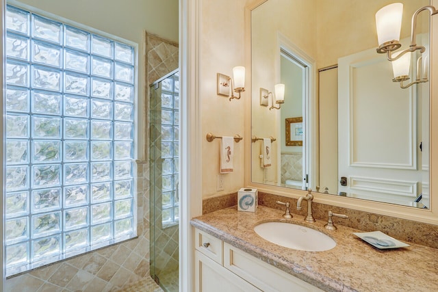 bathroom featuring plenty of natural light, a shower with door, and vanity