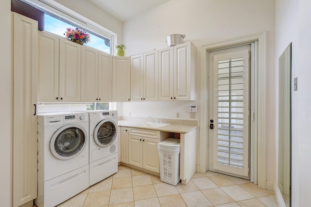 laundry area with independent washer and dryer, light tile floors, cabinets, and sink