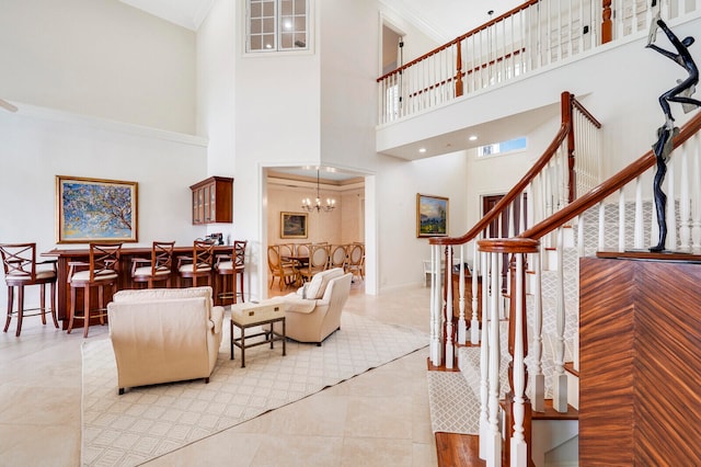 tiled living room with ornamental molding, a notable chandelier, and a towering ceiling