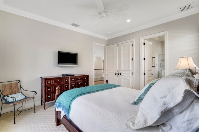 bedroom with ornamental molding, light carpet, ceiling fan, and connected bathroom