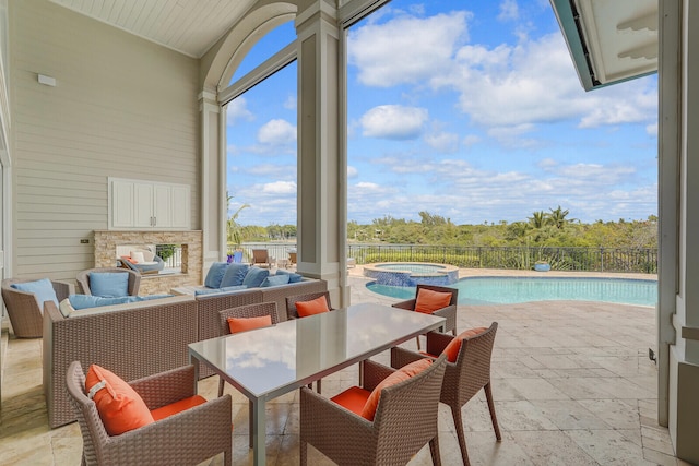 view of patio / terrace with an outdoor living space with a fireplace and a swimming pool with hot tub