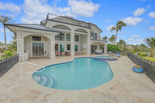 view of swimming pool featuring a patio, an in ground hot tub, and french doors