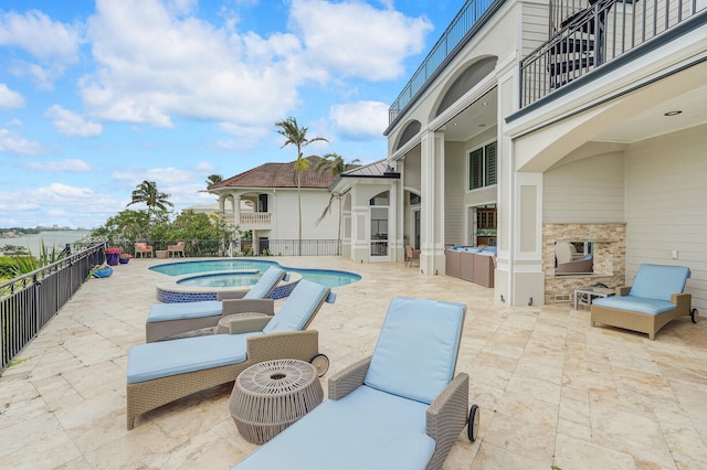 view of swimming pool featuring a patio area and an outdoor living space with a fireplace