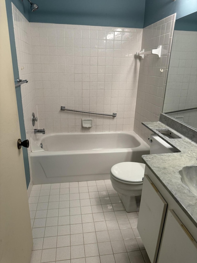 full bathroom with tile patterned floors, vanity, tiled shower / bath combo, and toilet