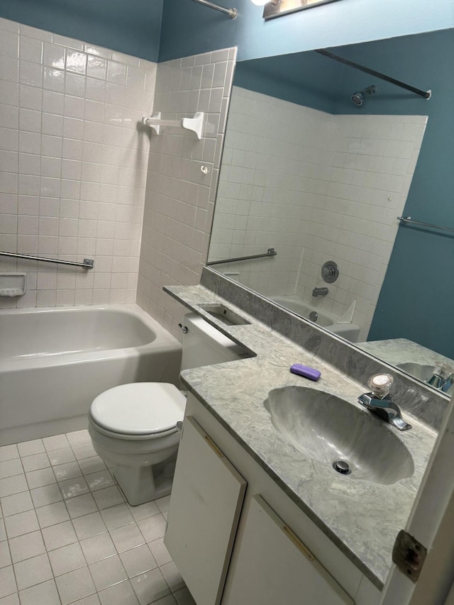 full bathroom featuring tile patterned floors, vanity, tiled shower / bath, and toilet