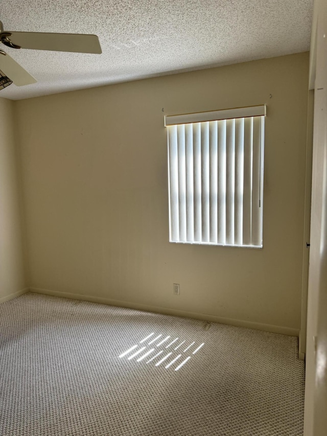 spare room with a textured ceiling, carpet floors, and ceiling fan