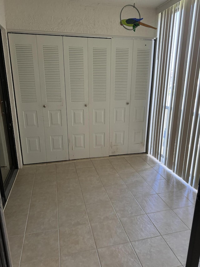 unfurnished bedroom with a closet and light tile patterned floors