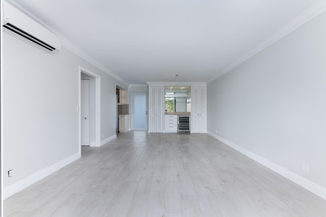 unfurnished living room featuring wine cooler, ornamental molding, light wood-type flooring, and a wall unit AC