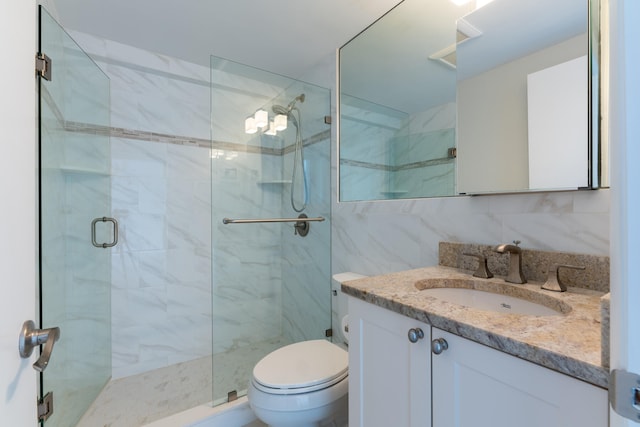 bathroom featuring toilet, a shower with door, vanity, tasteful backsplash, and tile walls