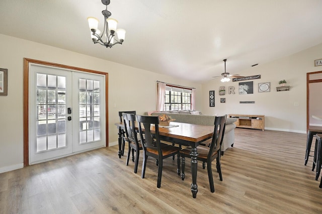 dining room featuring french doors, ceiling fan with notable chandelier, vaulted ceiling, and light wood-type flooring