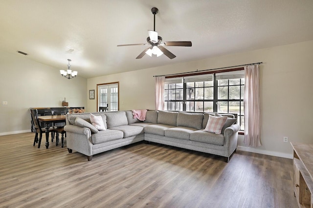 living room featuring wood-type flooring and ceiling fan with notable chandelier