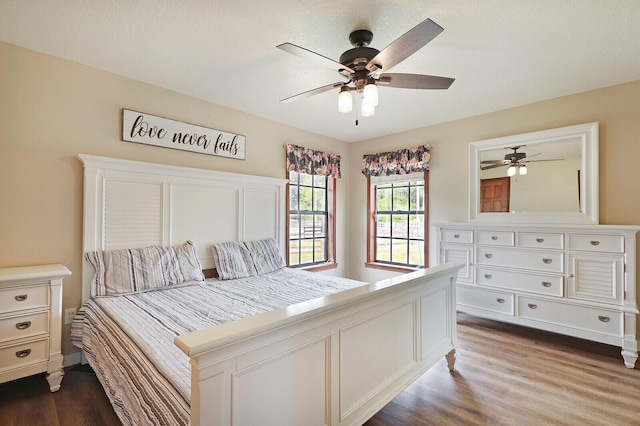 bedroom featuring hardwood / wood-style flooring, a textured ceiling, and ceiling fan