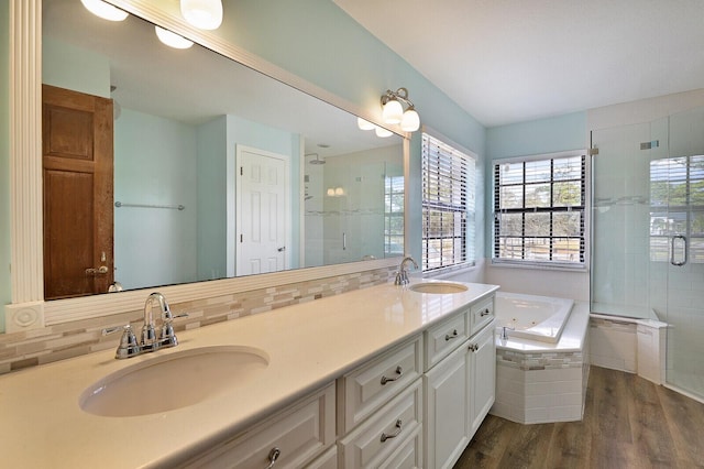 bathroom featuring wood-type flooring, separate shower and tub, vanity, and backsplash