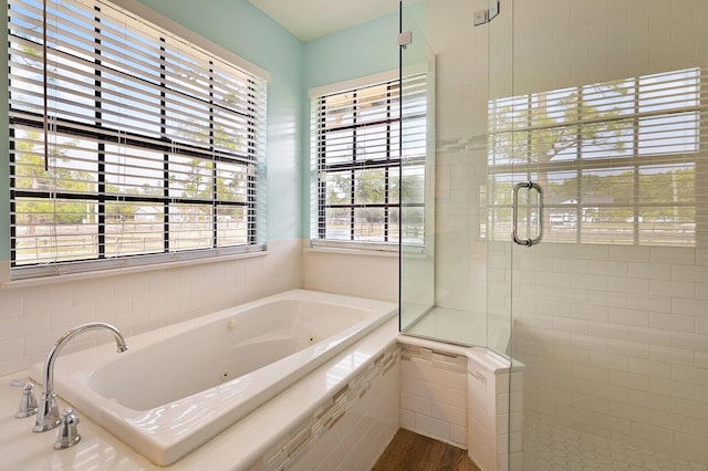 bathroom with independent shower and bath and hardwood / wood-style flooring