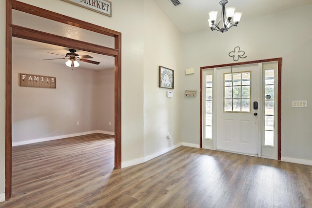 entryway with dark hardwood / wood-style floors and ceiling fan with notable chandelier