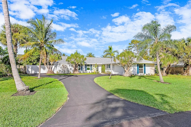 ranch-style house featuring a garage and a front lawn