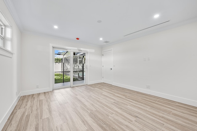 spare room featuring crown molding and light hardwood / wood-style floors