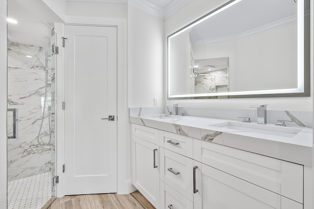 bathroom featuring a shower with shower door, crown molding, hardwood / wood-style floors, and double sink vanity