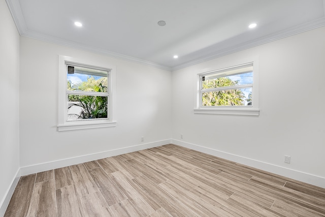 empty room with light hardwood / wood-style floors and crown molding