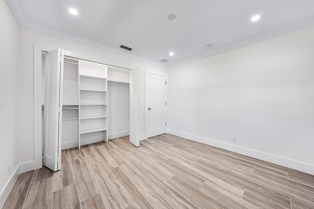 unfurnished bedroom with crown molding, a closet, and light hardwood / wood-style floors