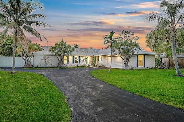 single story home with a lawn