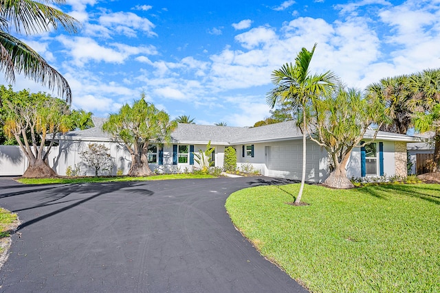 single story home featuring a garage and a front lawn