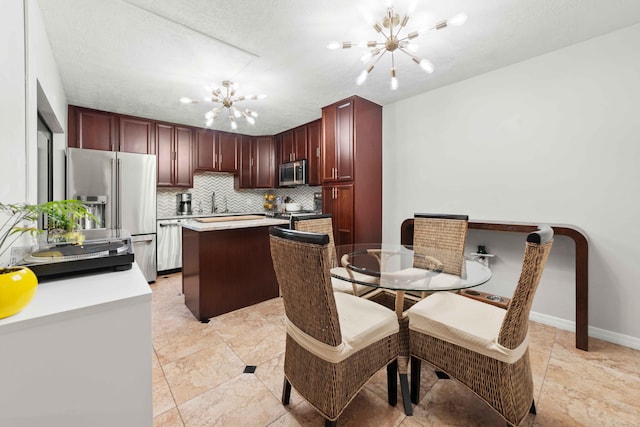 kitchen with light tile floors, a chandelier, tasteful backsplash, and stainless steel appliances