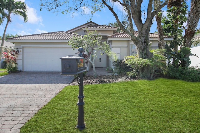 view of front of home with a front yard and a garage