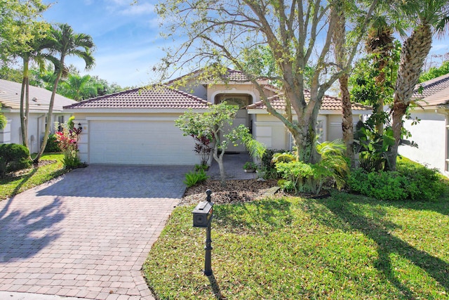 mediterranean / spanish home with a garage and a front lawn