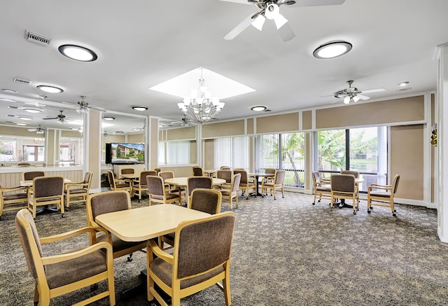 carpeted dining room with ceiling fan with notable chandelier