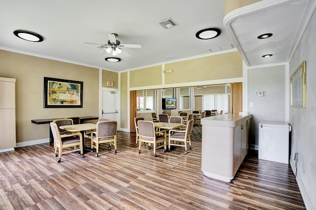 dining room with wood-type flooring, ceiling fan, and ornamental molding