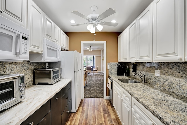 kitchen with white cabinetry, white appliances, ceiling fan, and light hardwood / wood-style flooring