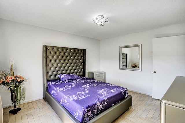 bedroom with light parquet floors and a textured ceiling