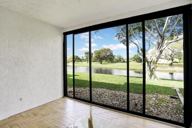 interior space with light parquet flooring and a water view