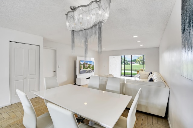 dining room with light parquet flooring and a textured ceiling