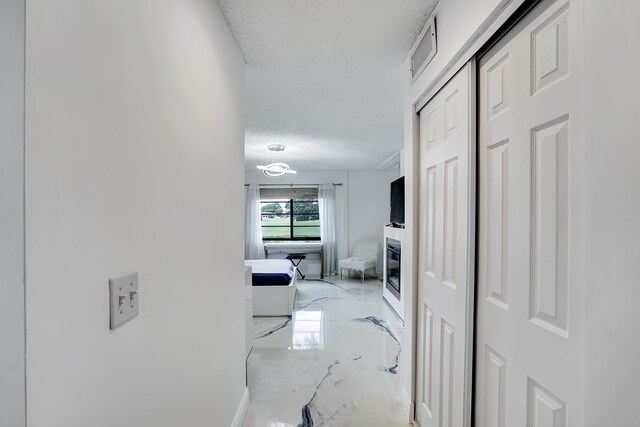 hall featuring a textured ceiling