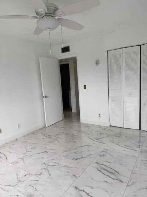 unfurnished bedroom featuring a closet, marble finish floor, visible vents, and baseboards