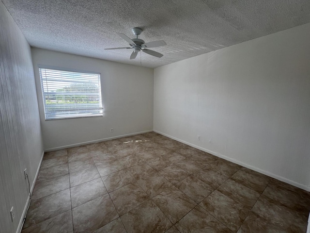 empty room featuring ceiling fan, a textured ceiling, and baseboards