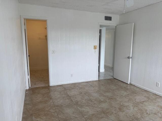 unfurnished room with a ceiling fan and visible vents