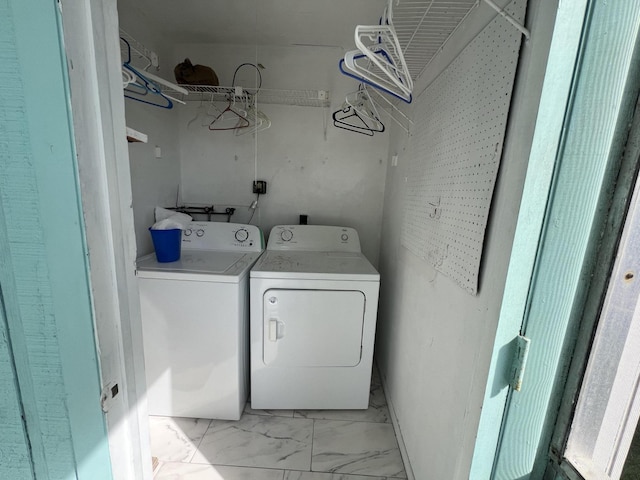 laundry room featuring marble finish floor, laundry area, and washing machine and clothes dryer