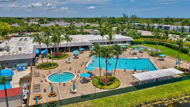 community pool with a patio area and fence