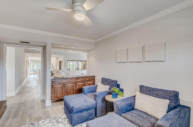 living area featuring light hardwood / wood-style flooring, ceiling fan, and crown molding