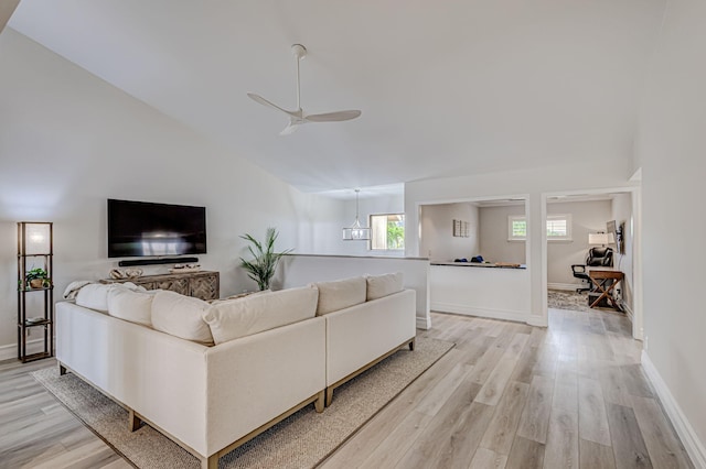 living room featuring light hardwood / wood-style floors, ceiling fan, and lofted ceiling